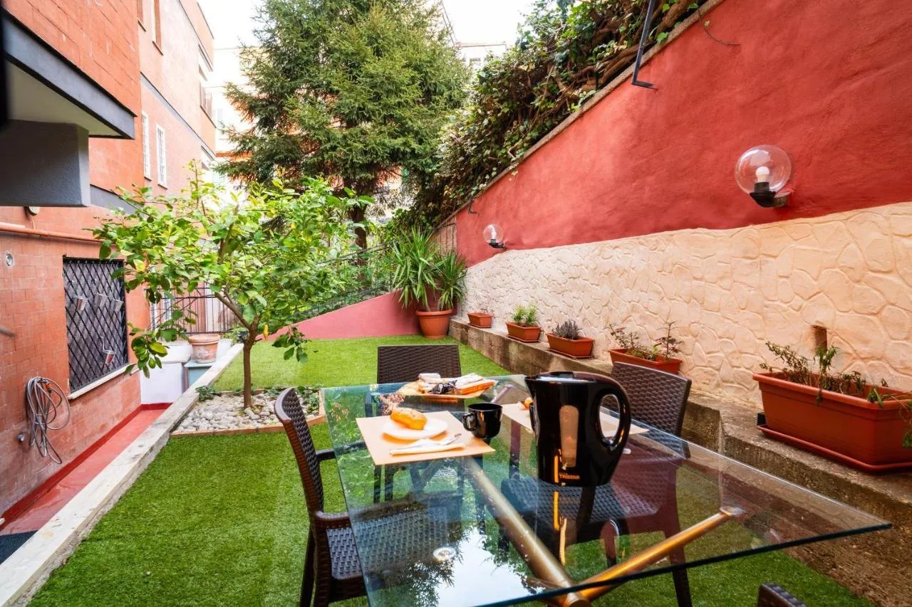Il tavolo del giardino apparecchiato, con il muro di pietra e le piante